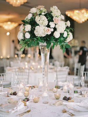 floral centerpiece with trumpet vase and white linen