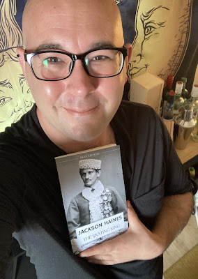 Photograph of author Ryan Stevens with a copy of the book "Jackson Haines: The Skating King"