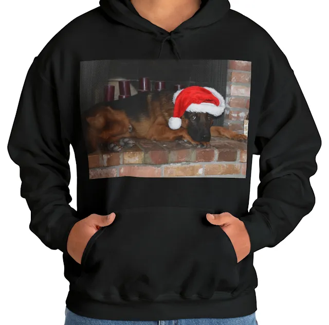 A Hoodie With Black and Red German Shepherd Wearing a Christmas Cap Lying on a Fireplace