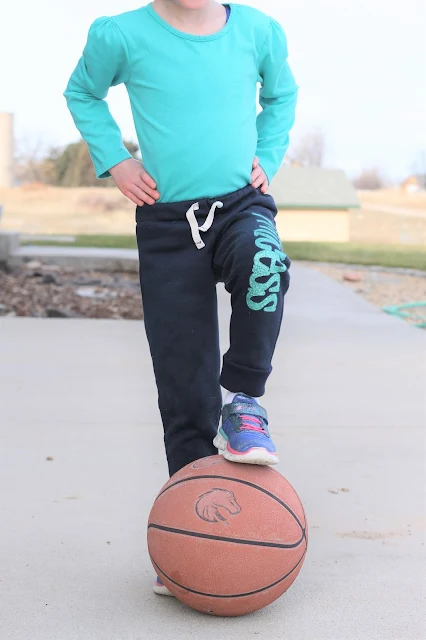 Girl in jogger pants with basketball