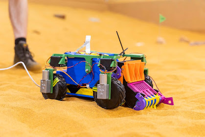 Picture of the actual rover, with trademark multicolour aesthetic, settling well into its natural environment of "Mars"