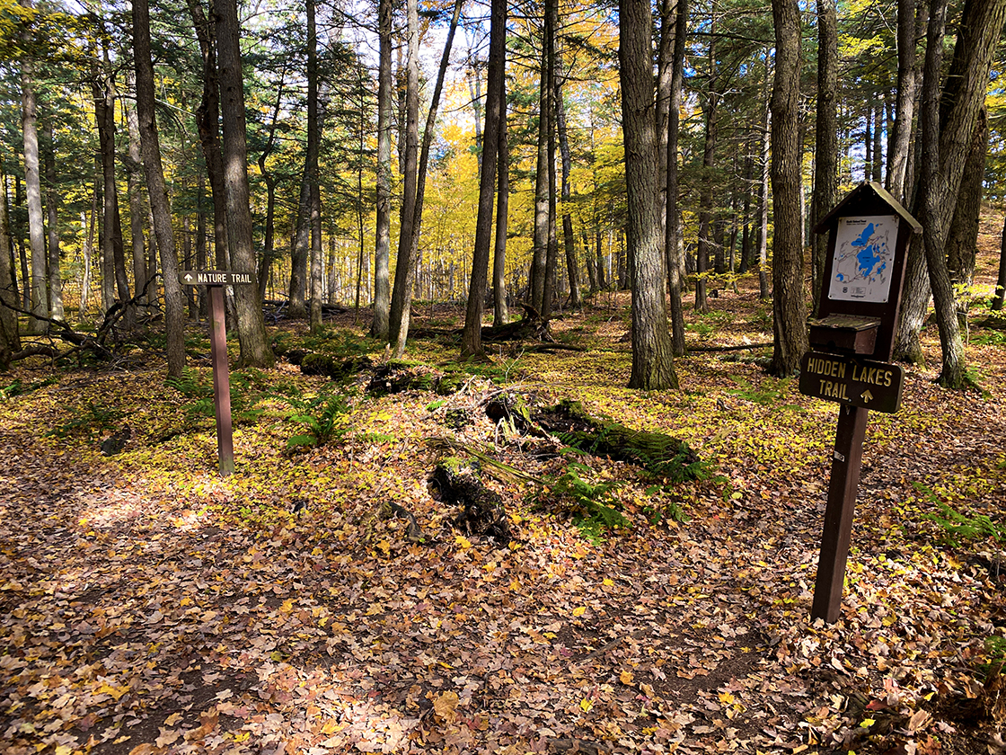 Diverging trails with trail map posted, Sign reads Hidden Lakes Trail