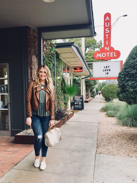 Tourist standing in front of Austin Motel sign