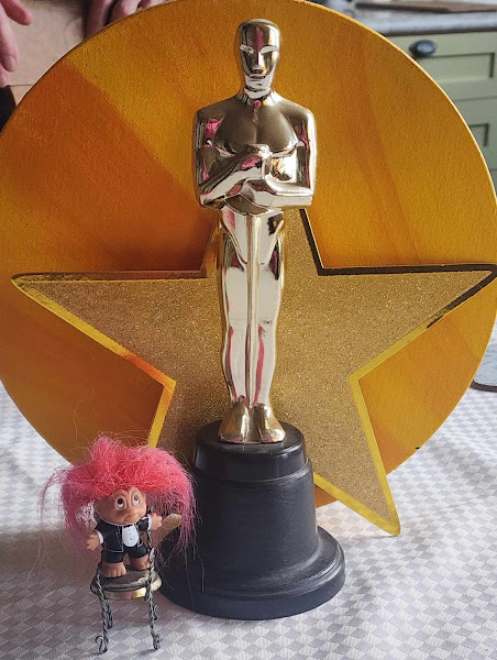 Close-up of the troll and oscar statue in front of a gold star