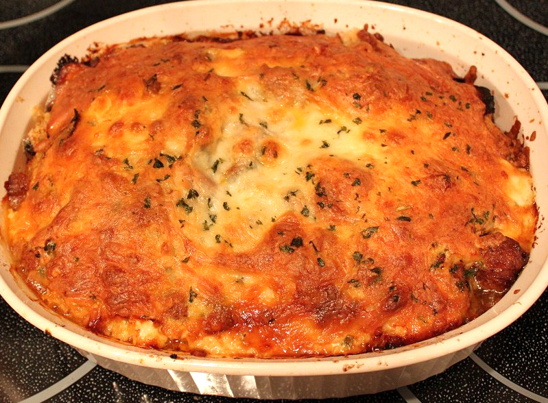 this is a casserole of spaghetti pie with sauce, ground beef topped with lots of melted cheese