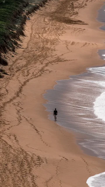 Homem Caminhando na Praia Sozinho