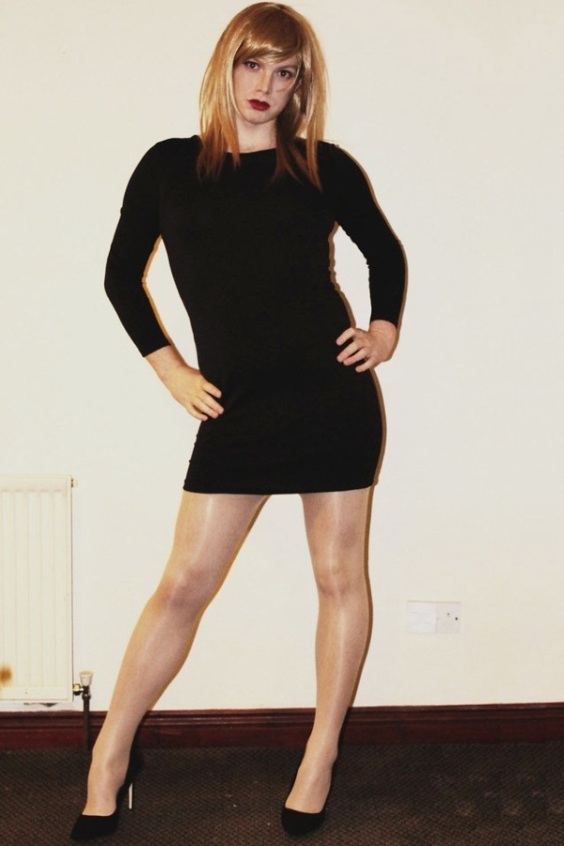 Pretty crossdresser wearing a minidress, pantyhose and high heels
