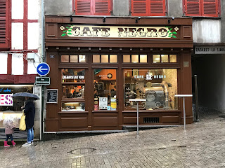 Tienda, panadería cafeteria de cafe y calle en pendiente empedrada