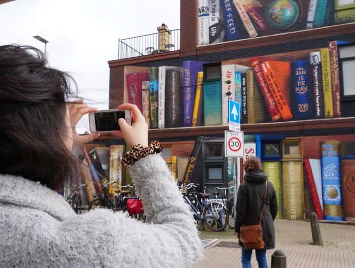 Dutch Artists Paint An Enormous Bookcase On An Apartment Building That Features Residents’ Favorite Books