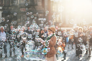 Woman standing in a cloud of bubbles.