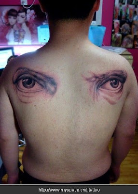 complimentary tattoo design with two eyes inked on two sides of the shoulder
