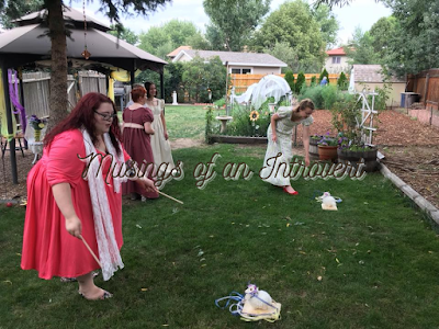 Regency ladies playing a game of throwing a beribboned ring around a toy sheep