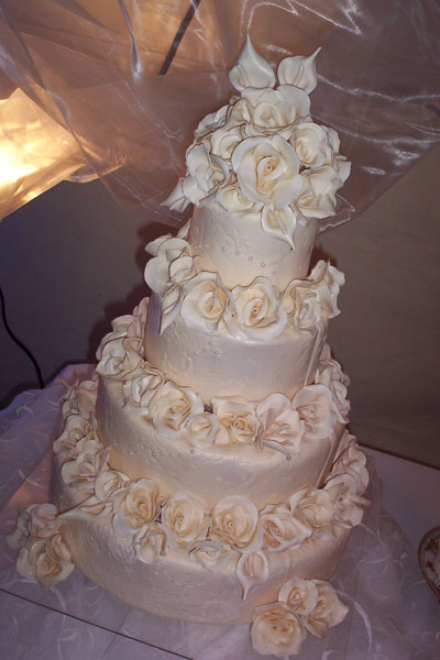 Elegant three tier round wedding cake with sugar roses emphasizing the 