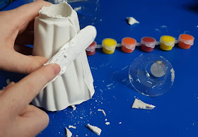  tidy up rough edges of plaster model volcano using wooden lollipop stick