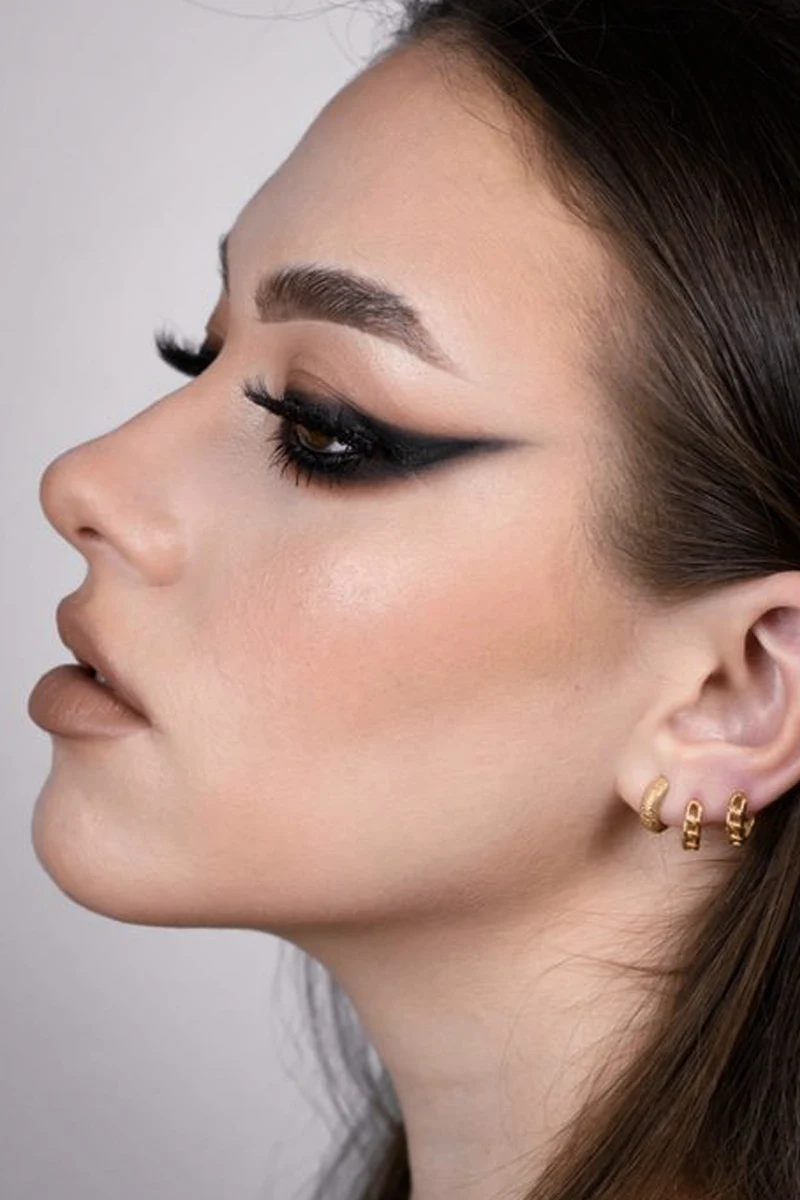 close-up portrait of a young, beautiful woman with goth eyeliner makeup look