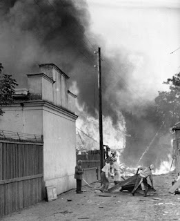 Польские мирные жители у горящего дома на окраине Варшавы.