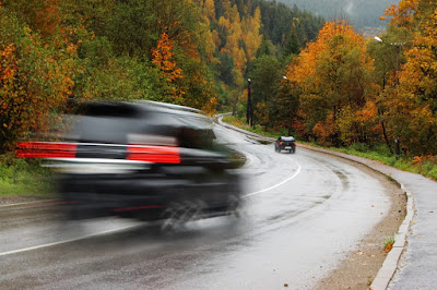 cars driving on damp fall road