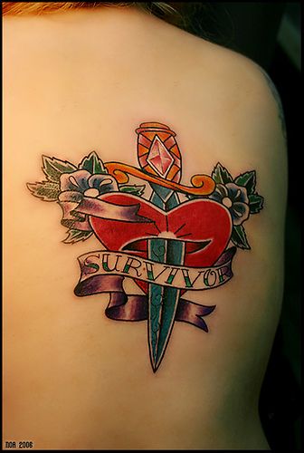 Heart and dagger with flowers tattoo.