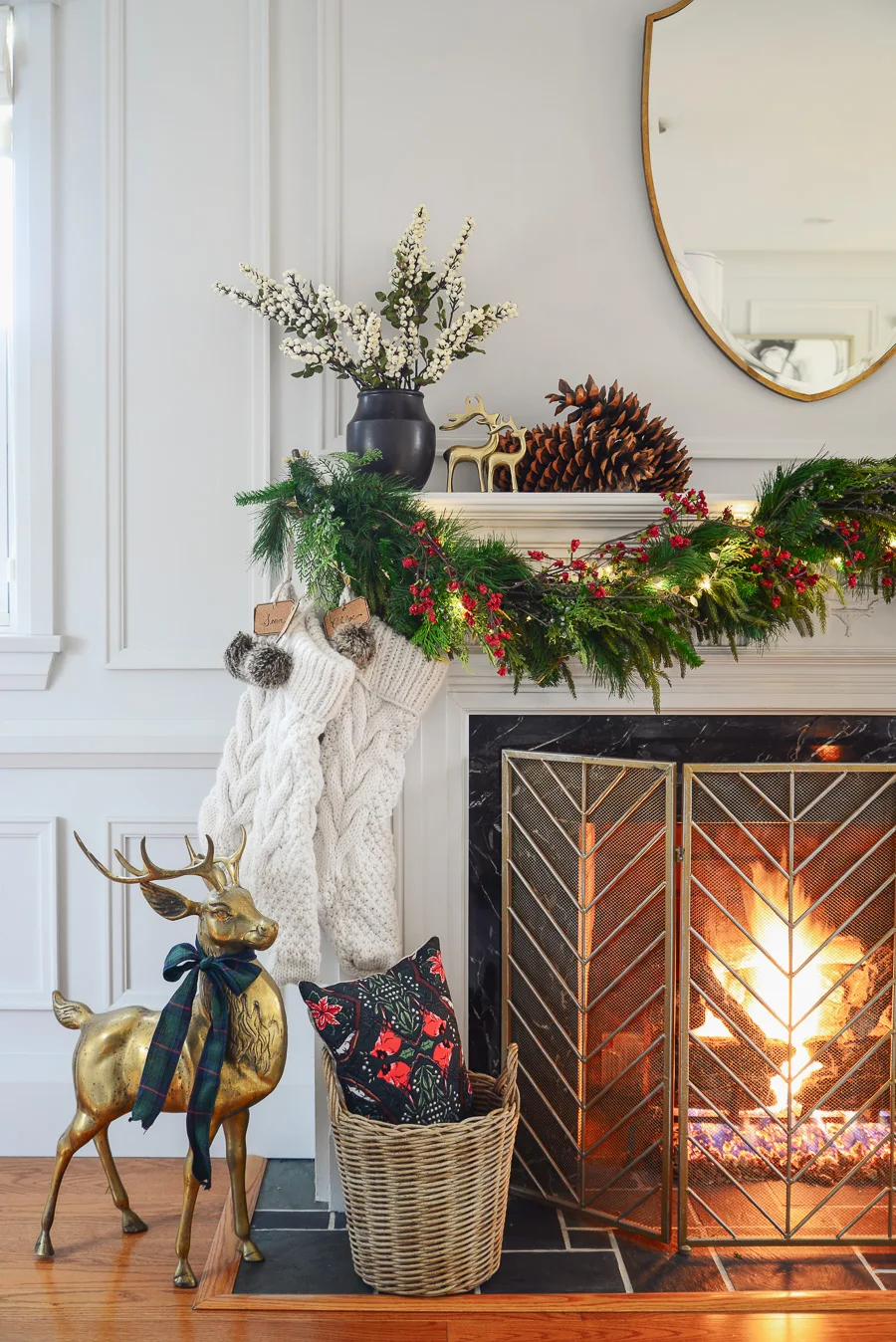 traditional christmas mantel decor with faux garland, mirror, brass deer