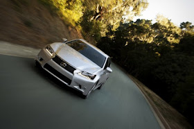 Front view, tilted, of 2012 Lexus GS350 driving toward the camera on two lane winding road