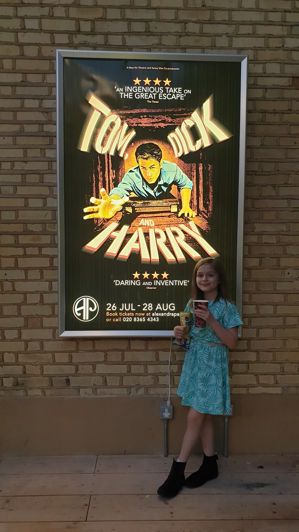 a theatre poster with a child pointing at it