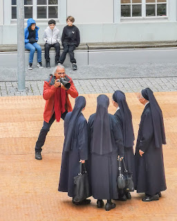 Anlässlich des Bistumsfests lassen sich vier Ordensschwestern fotografieren, beobachtet von drei Jugendlichen.