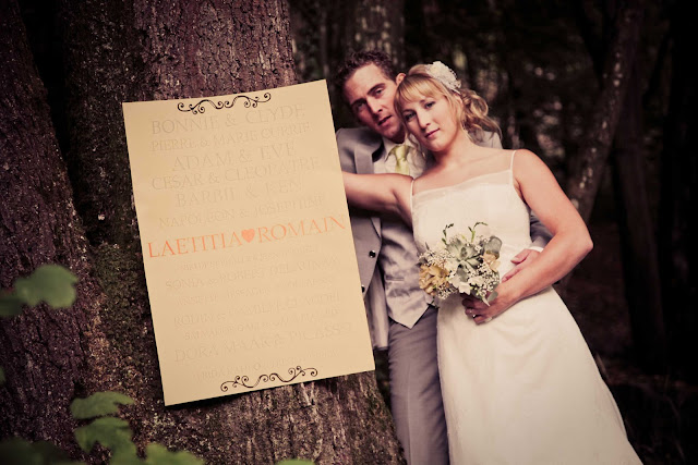 A bride and a groom next to a tree in a forest