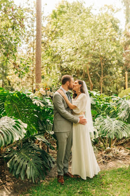 bride and groom kissing surrounded by tropical trees