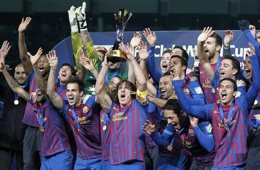 Barcelona captain Carles Puyol holds the Club World Cup trophy on the podium