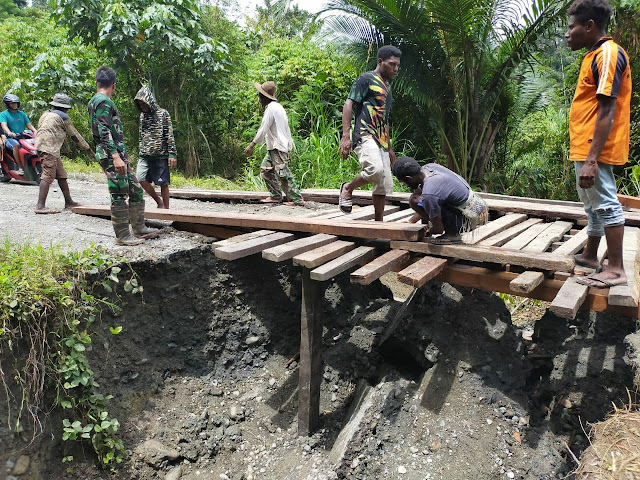 Akibat Jalan Longsor, Satgas TNI Pamtas Yonif 403/WP Bersama Masyarakat Bangun Jembatan di Jalur Trans Papua