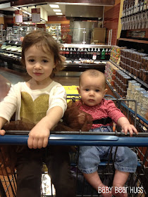 two little girls in a shopping cart