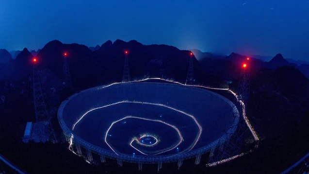 La antena parabólica FAST, en China, iluminada por la noche. Crédito: Agencia de Noticias Xinhua
