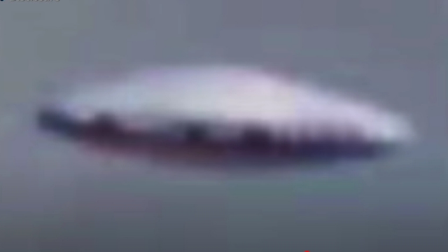 Flying Saucer flies out of the clouds and nearly hits an airplane.