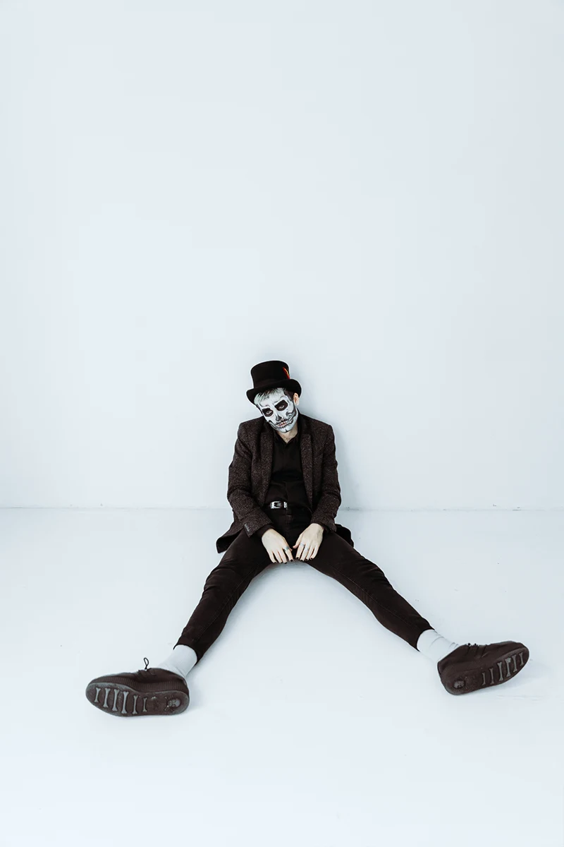 studio portrait of a man in a halloween costume with skull makeup look