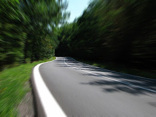 road to forge ahead with forests by the side showing speed perspective