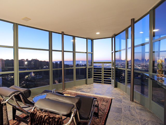 Photo of the room with two leather chairs and glass walls to provide incredible views