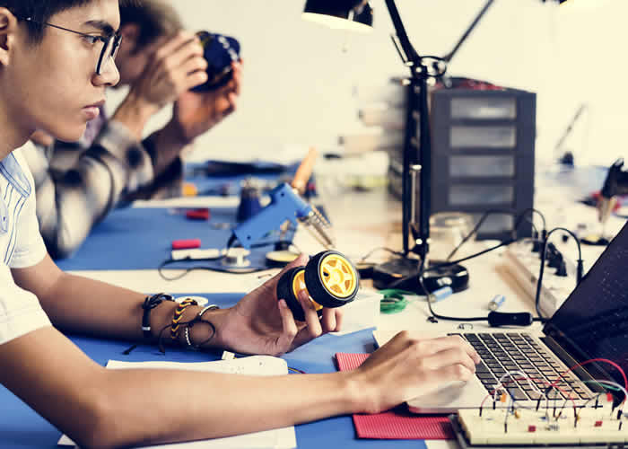 Sala com pessoas desenvolvendo projetos de robótica no movimento Make - Fab labs