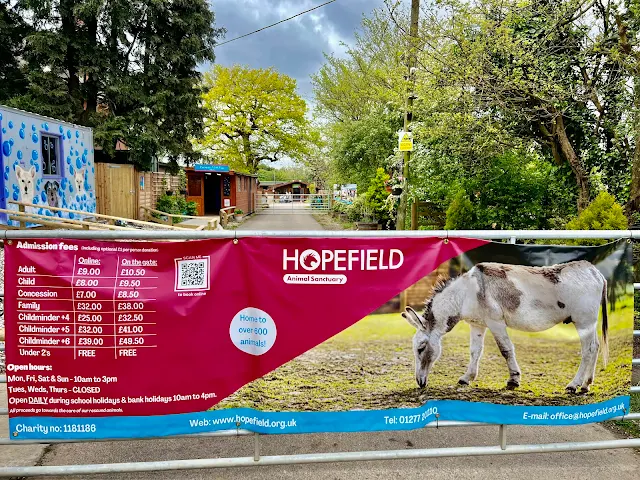The entrance to Hopefield Animal Sanctuary with a sign showing entry prices and times