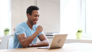 young man reading about publishing on laptop