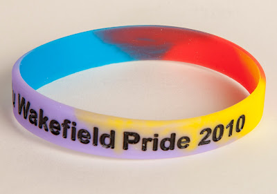 Multicoloured rainbow wristband with 'Wakefield Pride 2010' on in black letters