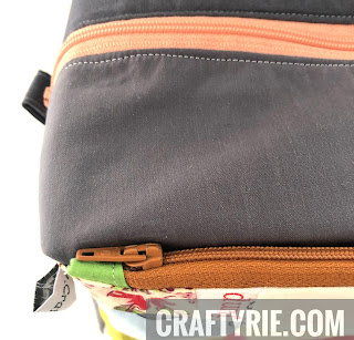 Front zipper view of boxy pouch with tag showing