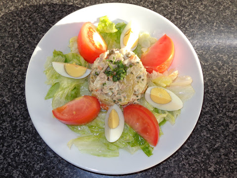 PORCIONES: 6  INGREDIENTES PARA LA ENSALADA DE PAPAS 3 papas lavadas de tamaño mediano 240 g de atún cocido o 2 latas drenadas ½ cebolla cortada en cuadritos 1 zanahoria larga cortada en cuadritos y cocida 252 g de arvejas cocidas o 1 lata drenada  ADEREZO ½ taza de mayonesa ¼ taza de aceite de oliva 3 cucharadas de vinagre rosado ¼ taza de cilantro picado 1 cucharadita de sal ¼ cucharadita de pimienta en polvo  OTROS INGREDIENTES Lechuga cortada en trozos Extracto de limón Aceite de oliva Sal, pimienta a su gusto Huevos cocidos duros, cortados en 4 gajos c/u Tomates cortados en gajos  METODO Poner una hoya con bastante agua a hervir. Poner las papas en la olla, bajar el fuego y cocinar lentamente por unos 20 minutos o hasta que al insertar un palillo este se introduzca fácil. Sacar del agua y dejarlas a enfriar. Lo ideal es cocinarlas el día anterior de hacer la ensalada. Una vez que las papas están bien frías cortarlas en cubitos. Poner  en una ensaladera los cubitos de papas con el atún desmenuzado, cebolla, zanahoria cocida, y arvejas. En un pocillo batir todos los ingredientes del aderezo y mezclar con la ensalada de papas. Refrigerar la ensalada hasta el momento de su uso. En una ensaladera hacer un aderezo mezclando el jugo de limón con el aceite, sal y pimienta. Agregar la lechuga y mezclar. Poner en los platos una cama de la ensalada de lechuga. En el centro poner ensalada de papas con atún. Terminar decorando con los tomates y huevos. Si desea puede agregarle aceitunas y pickles.  CONSEJO: cuando hace ensaladas que contienen pescado y mayonesa, lo ideal es que estos ya hayan sido refrigerados por unas horas o el día anterior antes de hacerlo. Así protegerá contra crecimiento de bacteria, evitará malestares de estómago.