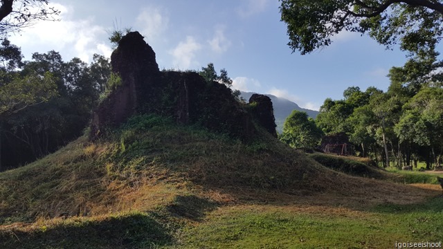 Bomb craters on the left and right of a destroyed structure.