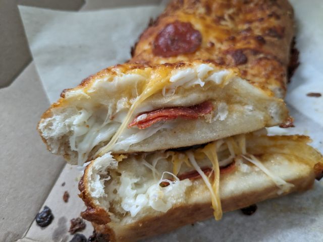 Domino's Pepperoni Stuffed Cheesy Bread cross-section with visible pepperoni.