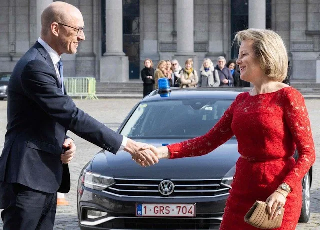 Queen Mathilde wore a red lace dress by Natan Couture. Giorgio Armani clutch. Christine Bekaert Lotus stud gold earrings