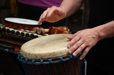 man playing djembe hand drum