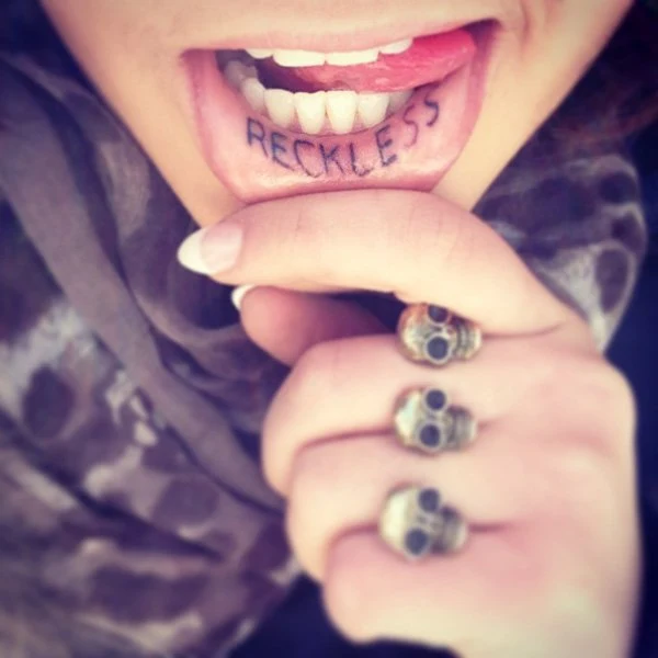tatuaje en el labio de una mujer que dice imprudente