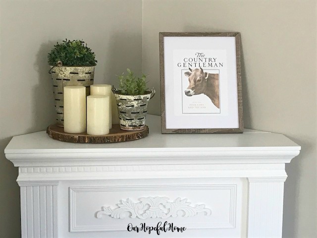 cow art in frame wood slice riser LED candles olive buckets