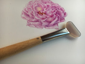 Painting of a pink rose with an agate burnisher 