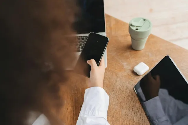 Persona manejando un teléfono móvil y laptop en actividades relacionadas con ciberseguridad